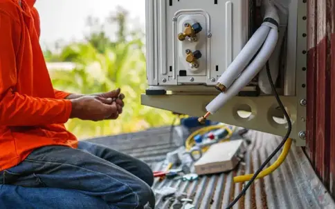 A technician installs an outdoor air conditioning unit