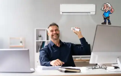 A man on his working table holding a remote pointing to AC