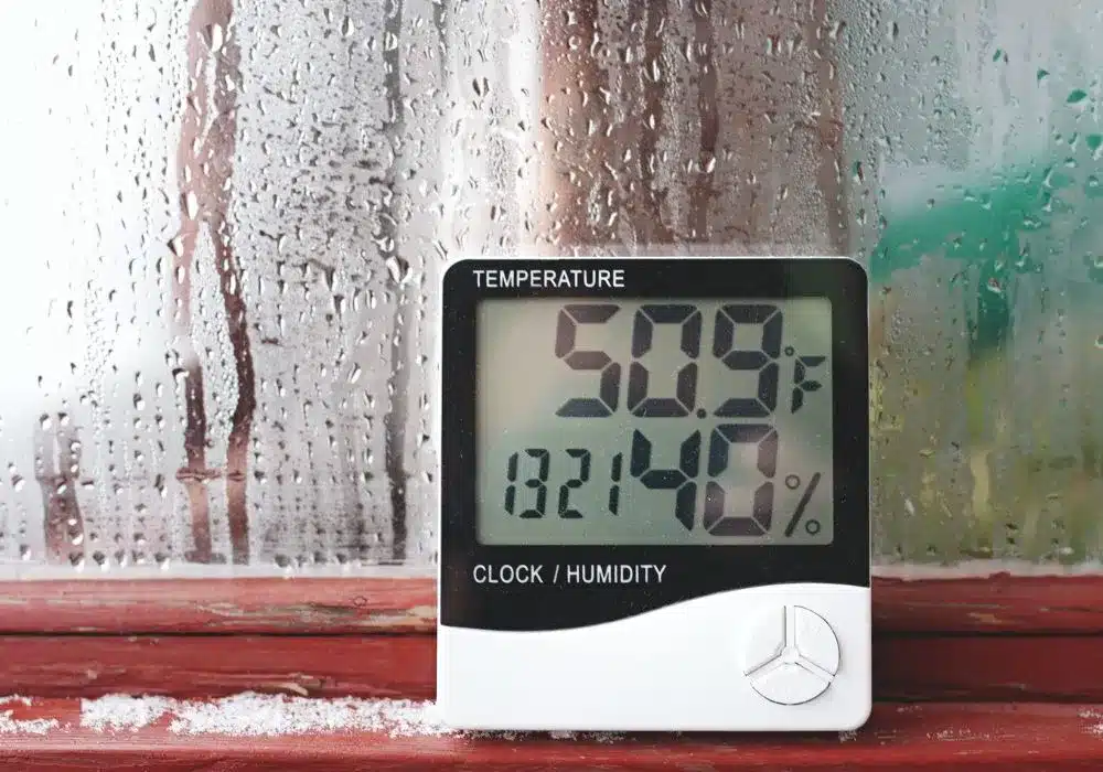 A digital thermometer and hygrometer displays 50.9°F and 40% humidity, positioned against a condensation-covered window.