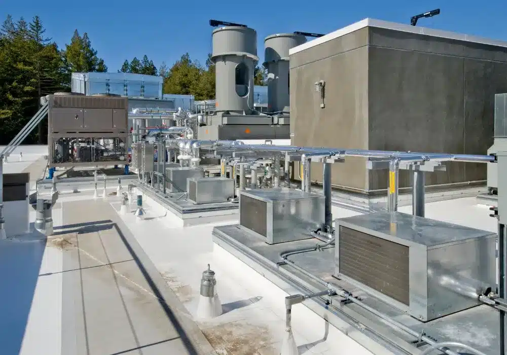 A commercial rooftop equipped with extensive HVAC systems, including multiple units, pipes, and vents.